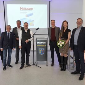 Dr. Jörg Probst (Leiter DIZ Stadtallendorf), Kreistagsvorsitzender Detlef Ruffert, Bürgermeister Christian Somogyi, Landrat Jens Womelsdorf, Prof. Dr. Christian Kleinschmidt (Philipps-Universität Marburg), Anna M. Becker und Dr. Markus Morr (Fachdienst Kultur und Sport), (v.l.n.r.)