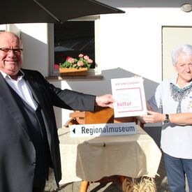 „Hinz Hoob“ in Gladenbach-Weidenhausen ist nun Teil der Route der Arbeits- und Industriekultur des Landkreises Marburg-Biedenkopf. Der Kreisbeigeordnete Roland Petri überreicht Anneliese Müller vom Heimatverein Weidenhausen die Plakette.