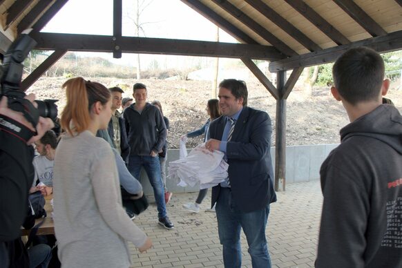 Der erste Kreisbeigeordnete Marian Zachow verteilt T-Shirts an die Helferinnen und Helfer. 50 Schülerinnen und Schüler der Europaschule Gladenbach beteiligten sich während einer Projektwoche an der Neugestaltung des Pausenhofes.