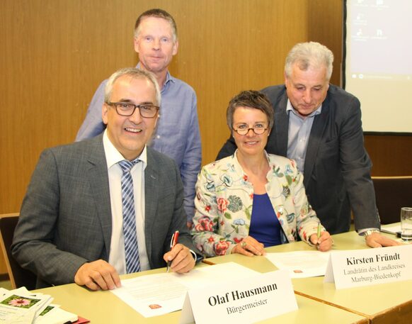 Bürgermeister Olaf Hausmann (vorne li.) und Landrätin Kirsten Fründt unterzeichnen die Absichtserklärung für das Multifunktionshaus. Der Stadtverordnetenvorsteher Klaus Weber (re.) und Ortsvorsteher Dieter Tourte engagieren sich für das Projekt.