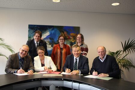 Pfarrer Ulrich Kling-Böhm (vorne li.) vom Diakonischen Werk Marburg-Biedenkopf, Erster Kreisbeigeordneter Marian Zachow, Landrätin Kirsten Fründt, Stadträtin Kirsten Dinnebier, Oberbürgermeister Dr. Thomas Spies, Silke Dünnebeil-Bediako vom Blauen Kreuz Marburg e.V. sowie Michael Kessler von der Bürgerinitiative Sozialpsychiatrie unterzeichnen die neue Vereinbarung zur Sucht- und Drogenberatung