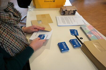 Eine Mitarbeiterin des Landkreises Marburg-Biedenkopf bereitet die Ehrenamtscards für den Versand vor