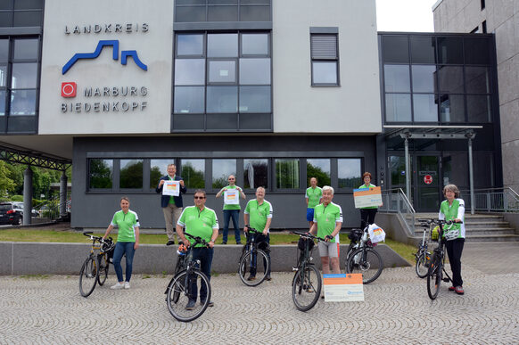 Beim Start der Organspende-Fahrradrunde durch Marburg vor dem Landratsamt kamen (von links nach rechts versetzt) Landrätin Kirsten Fründt, Oberbürgermeister Dr. Thomas Spies, Konrad Keßler, Manfred Wiegand und Martin Ronzheimer, Dr. Nils Ludwig vom Gesundheitsamt, Tour-Organisator Klaus Zinnecker, Monika Bäcker und Birgit Heitmann-Keßler zusammen.