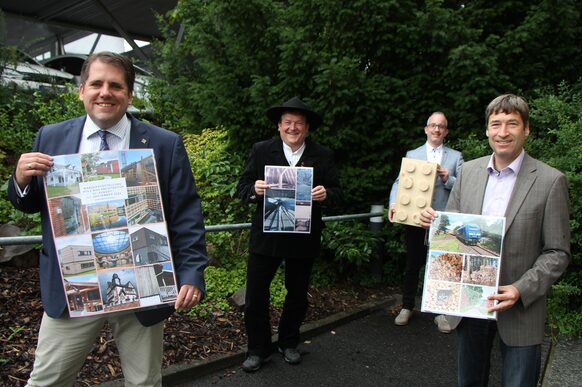 Werben für Holz als nachhaltigen Baustoff: Der Erste Kreisbeigeordnete Marian Zachow (v. li.), Hartmut Pfeiffer (Obermeister der Zimmererinnung), Alexander Hohbein (Geschäftsführer von pro holzbau hessen) sowie Wirtschaftsförderer Dr. Frank Hüttemann.