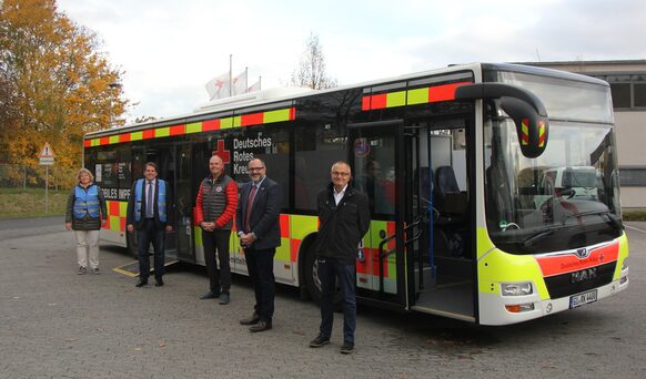 Vertreter_innen des Landkreises, des DRK und der Johanniter Mittelhessen vor dem Impfbus