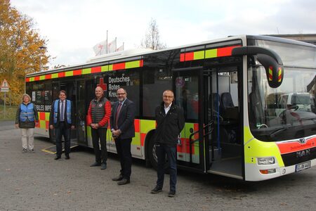 Vertreter_innen des Landkreises, des DRK und der Johanniter Mittelhessen vor dem Impfbus