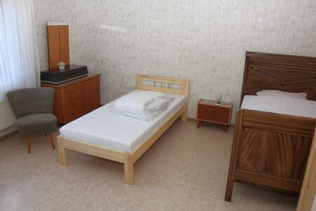 Zimmer mit zwei Betten und einem Sessel