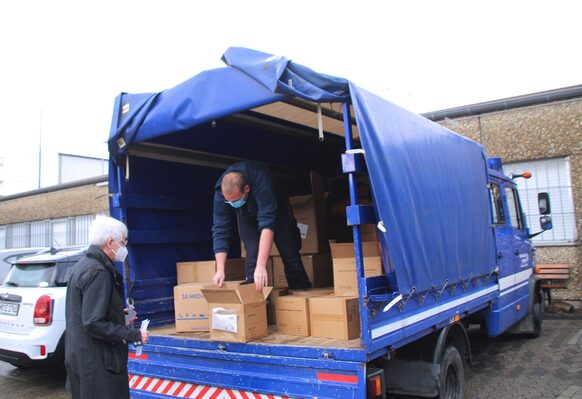 Zwei Männer räumen Kartons aus einem Transporter