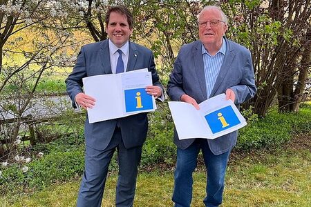 Der Erste Kreisbeigeordnete Marian Zachow (li.) und der ehrenamtliche Flüchtlingshelfer Kurt Bunke präsentieren den Wegweiser für Menschen, die Wohnraum an ukrainische Flüchtlinge vermieten wollen.