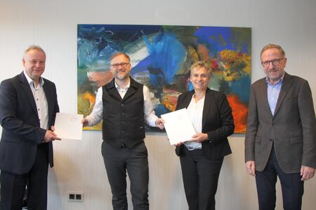 Landrat Jens Womelsdorf übereicht Vertretenden der Baugenossenschaften die Förderbescheide