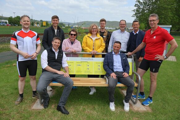 Gruppenbild: Die Akteurinnen und Akteure von Kreis, Sparkasse, Sportkreis und Kommunen stellen die neue Fitnessbank vor.