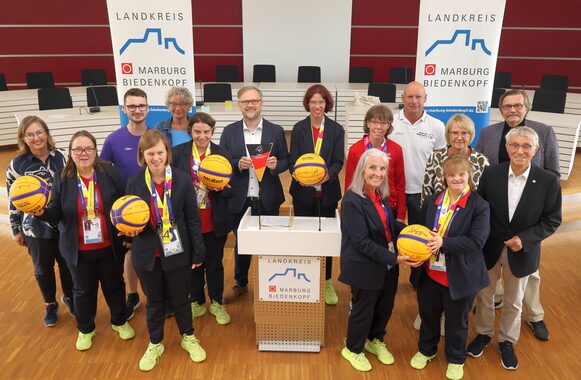 Landrat Jens Womelsdorf (hintere Reihe, Mitte) und der Kreistagsvorsitzende Detlef Ruffert (vordere Reihe, re.) haben im Marburger Kreishaus die beachtlichen Erfolge der Sportlerinnen aus Marburg-Biedenkopf bei den „Special Olympics World Games“ im Beisein ihrer Trainerinnen und Trainer und Begleitpersonen gewürdigt.