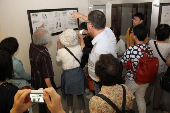 Interessiert betrachten die Besucher aus Japan die knapp 450 Zeichnungen, die im Landratsamt zu sehen sind, und lauschen den Erläuterungen von Professor Ozawa.