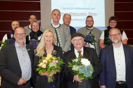 Die Otto-Ubbelohde-Preisträger Ursula Cyriax und Andreas Maria Schäfer (Mitte vorn) sowie Mitglieder des Trachtentanz- und Heimatvereins Lixfeld (hintere Reihe) bei der Preisverleihung gemeinsam mit Dr. Markus Morr (links) vom Fachdienst Kultur des Kreises und Landrat Jens Womelsdorf (rechts).