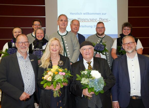 Die Otto-Ubbelohde-Preisträger Ursula Cyriax und Andreas Maria Schäfer (Mitte vorn) sowie Mitglieder des Trachtentanz- und Heimatvereins Lixfeld (hintere Reihe) bei der Preisverleihung gemeinsam mit Dr. Markus Morr (links) vom Fachdienst Kultur des Kreises und Landrat Jens Womelsdorf (rechts).