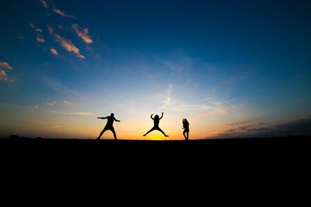 Springende Jugendliche im Sonnenuntergang