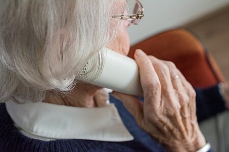 Profilansicht einer telefonierenden Seniorin