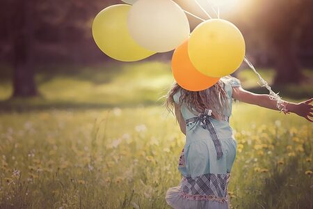 Rückenansicht eines Kindes mit Luftballons