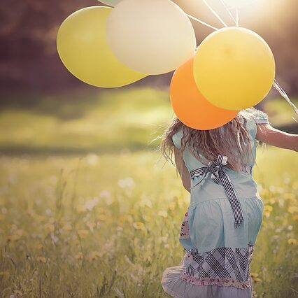 Rückenansicht eines Kindes mit Luftballons